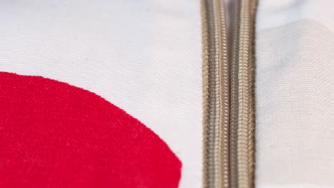 macro shot, opening the zip of a beutiful red and white cloth