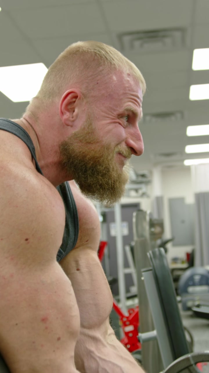 Bodybuilder muscoloso che solleva pesi. Persona atletica che si impegna
