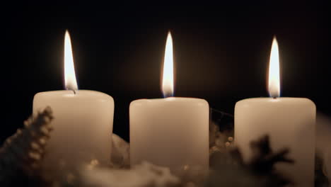 three burning candles in row blown out in slow motion