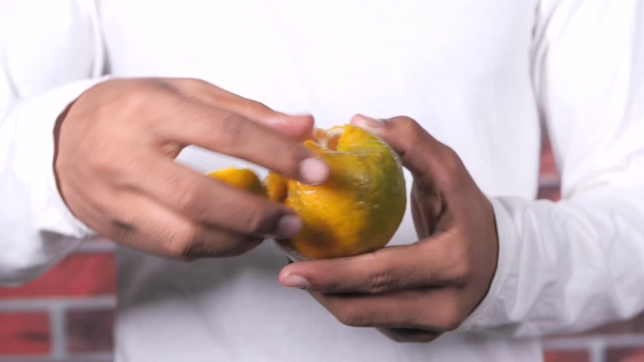 persona pelando una naranja