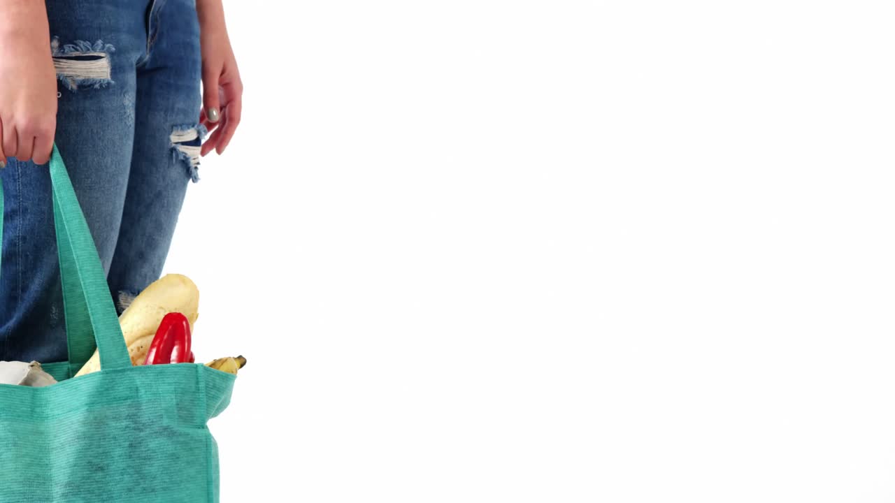 mujer caminando con una bolsa de comestibles