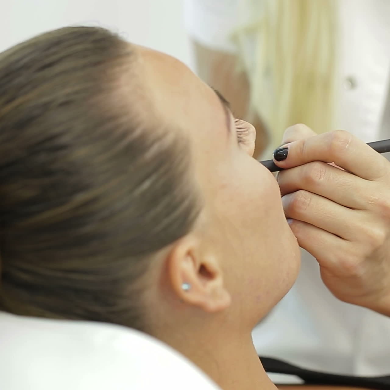 Permanent Make-up on her Lips. Portrait of lovely young woman getting permanent makeup on her lips