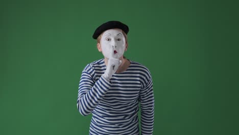 mime artist gesturing with finger on lips