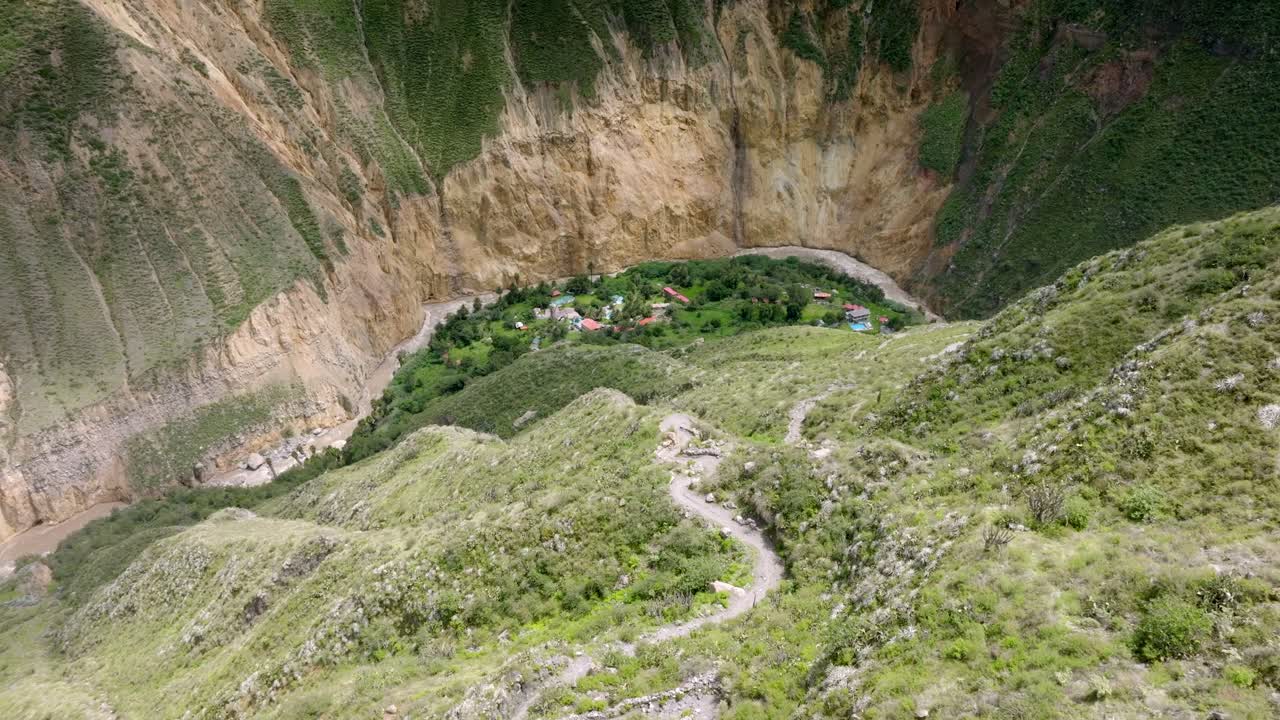 Drone shot of the steep descent from Cabanaconde to Sangalle, offering a breathtaking view of the lush Sangalle Oasis nestled in the Colca Canyon.