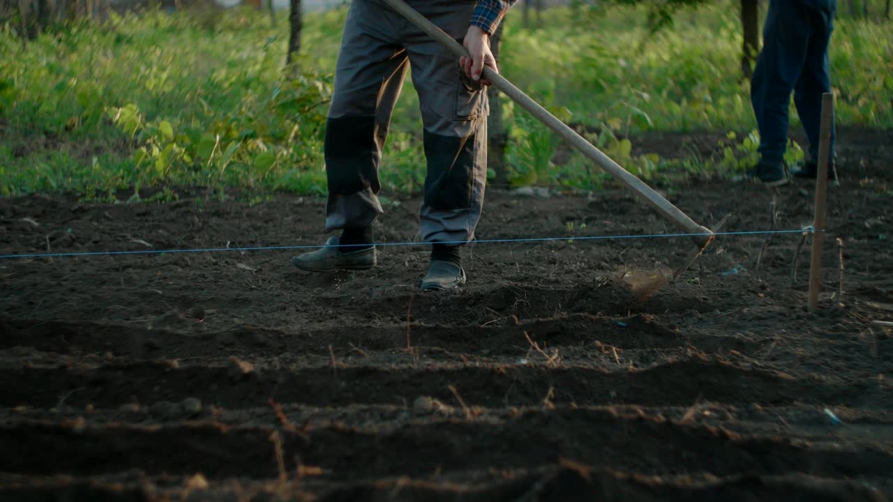 agricultor rompiendo la tierra con una azada para cultivar plantas en el campo