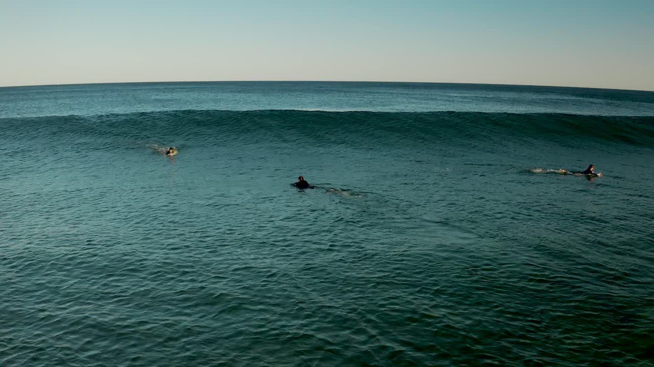 Surfer riding wave aerial at sunset Pacific ocean