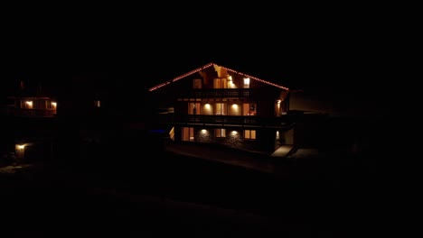 Muñeca-Aérea-De-Un-Hermoso-Chalet-Con-Lámparas-Encendidas-Y-Luces-Navideñas-Por-La-Noche