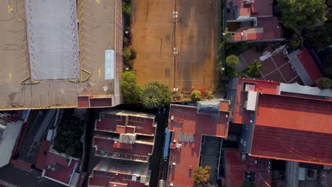 top view of tennis sports club surrounded by several houses and a parking lot in the morning, mexico city