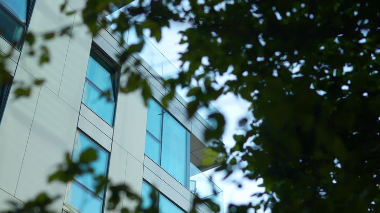 Edificio moderno che si intravede tra il fogliame verde, fondendo natura e architettura urbana
