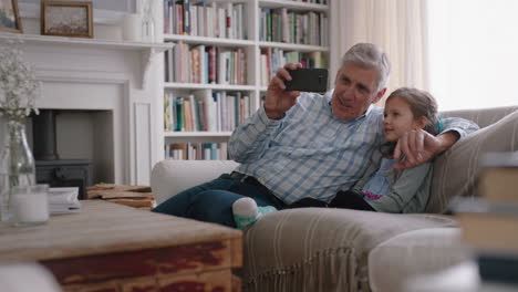 Abuelo-Y-Niño-Teniendo-Video-Chat-Usando-Teléfono-Inteligente-Niña-Compartiendo-Fin-De-Semana-De-Vacaciones-Con-La-Familia-Abuelo-Disfrutando-Charlando-Sobre-Tecnología-Móvil-En-Casa-Con-Nieta