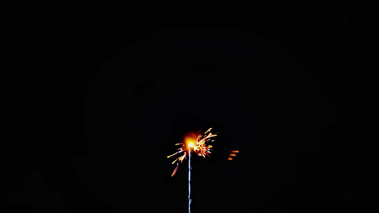 Close-up video of a vibrant firework explosion against a dark sky, captured from a low angle