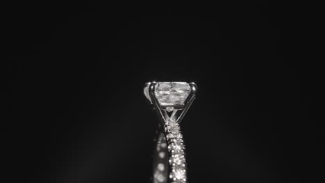 close up, luxurious diamond ring rotating against a black studio background