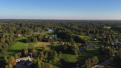 beautiful establishing shot of nitaure, latvia. slow and steady aerial rotation above the picturesque village surrounded by unspoiled beauty.