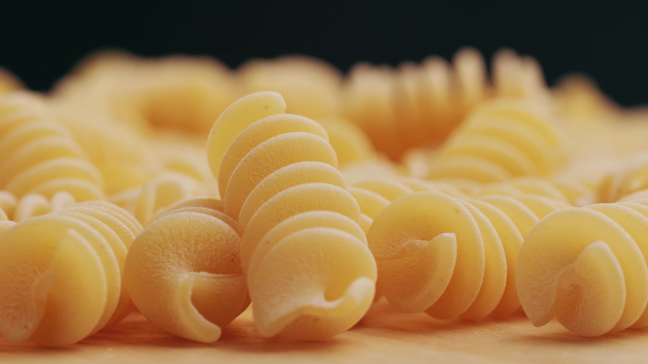 Primo piano di fusilli crudi su una superficie di legno