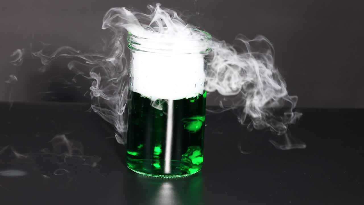 Dry ice creates smoke in green liquid