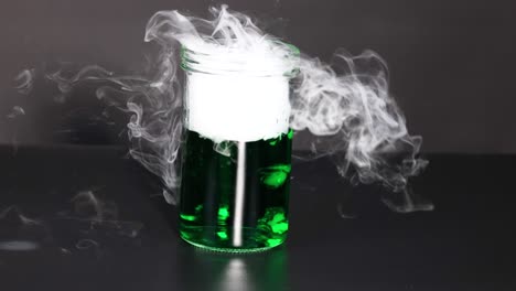 el hielo seco crea humo en líquido verde.