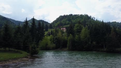 Aerial-approach-shot-of-lake-front-with-trees