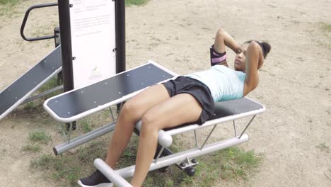 chica entrenando abdominales en el parque