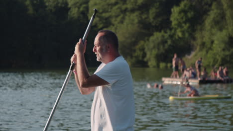 paddleboarding. an older man standing on a paddleboard