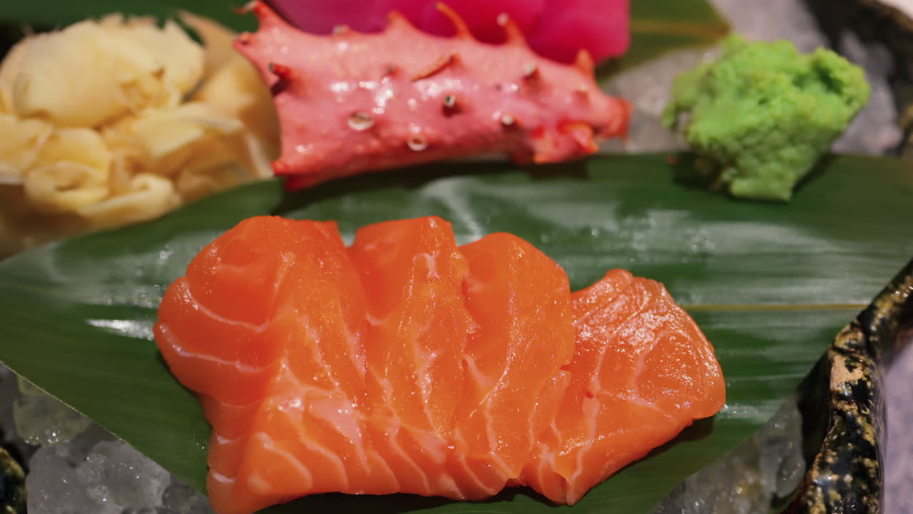 Close up of tuna and salmon sashimi on banana leaves on ice