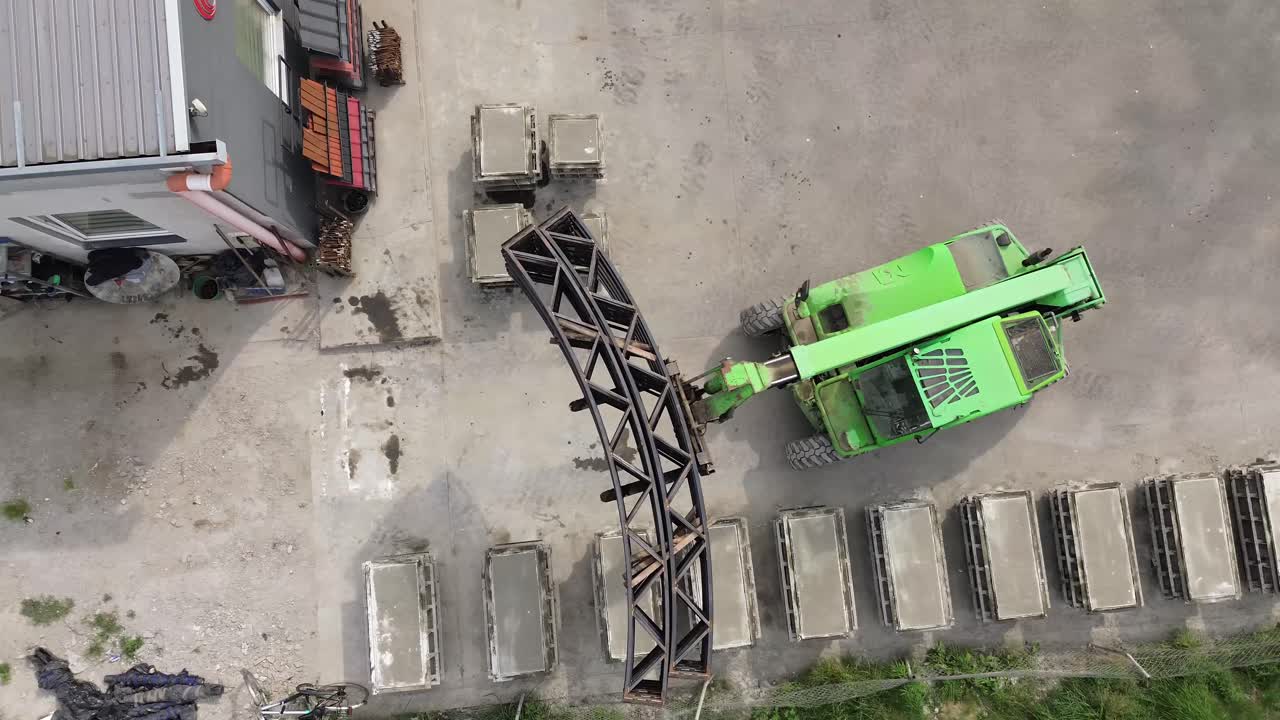 архитектурный подъем: лифт грациозно переносит сварные арки, симфония стали в строительном танце аркового зала, зафиксированная в этом захватывающем кадре