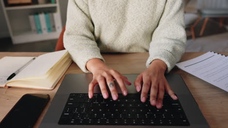 Business-woman-with-hands-typing-on-her-laptop
