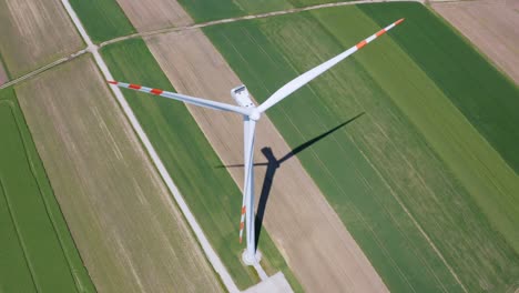 aerial orbit over the windmill standing alone in the middle of the farm fields