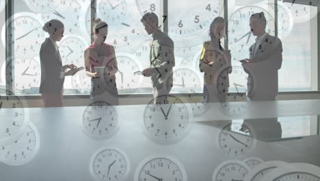 animation of clocks moving over diverse colleagues discussing work in office