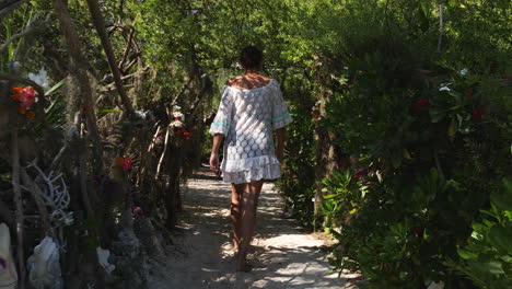 Una-Turista-Camina-Por-Un-Sendero-En-Una-Pequeña-Isla-Para-Almorzar-En-Farè-Hut,-Nueva-Caledonia