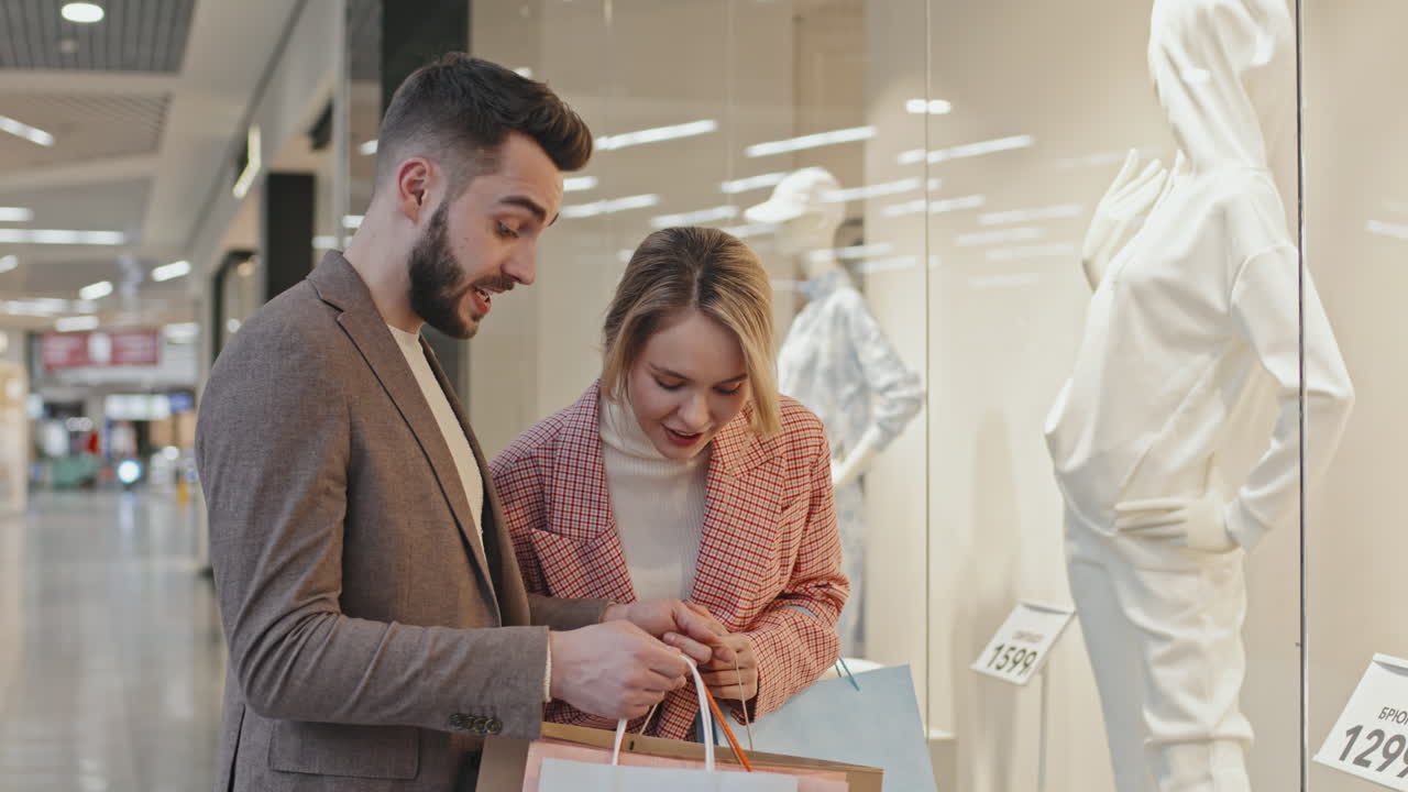 Happy Stylish Couple Looking Inside Their Shopping Bags