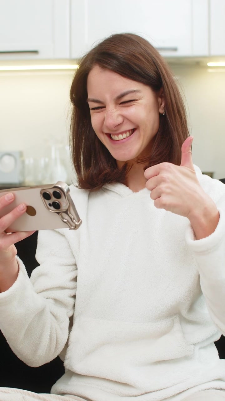 Giovane donna impara una lingua su un'app per smartphone, ripete frasi, ottiene un punteggio elevato, sorride orgogliosa per il massimo dei voti