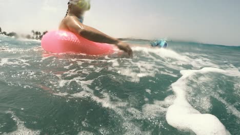 sea wave. a man and a woman on an inflatable ring ride the sea on a wave.