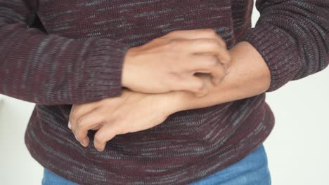 hombre rascándose el brazo con picazón