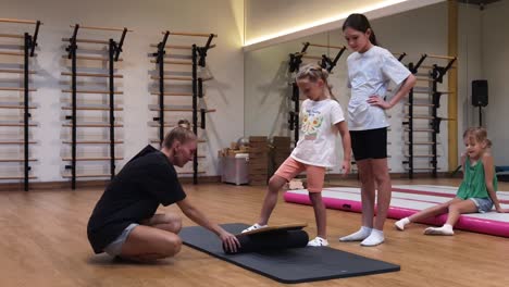 niños aprendiendo ejercicios de equilibrio en un gimnasio