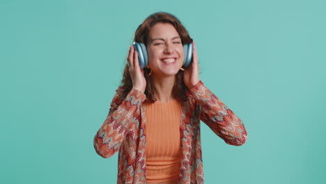 happy young woman in headphones listening music dancing disco having fun relaxing on christmas party