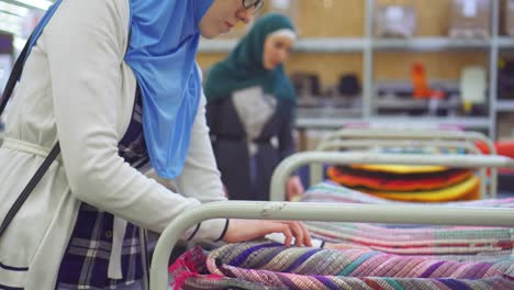 young muslim woman in hijab in carpet shop