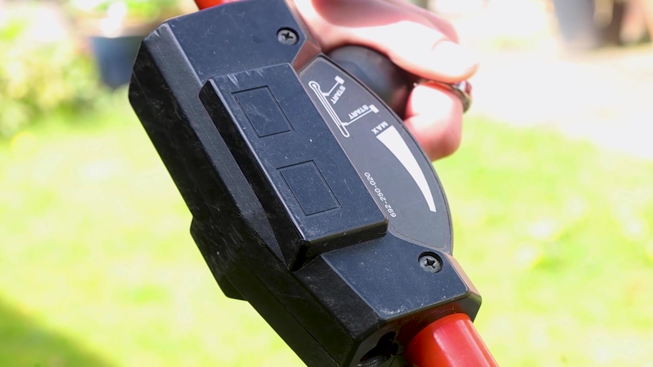 Video turning on a simple push mower in a garden.