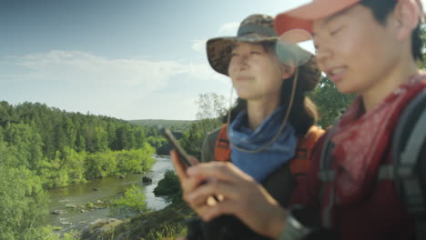asian women discussing hiking route on phone