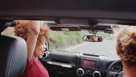 Un-Grupo-De-Jóvenes-Amigos-Conduciendo-Un-Coche-De-Alquiler-Con-Techo-Abierto-En-Vacaciones-De-Verano.