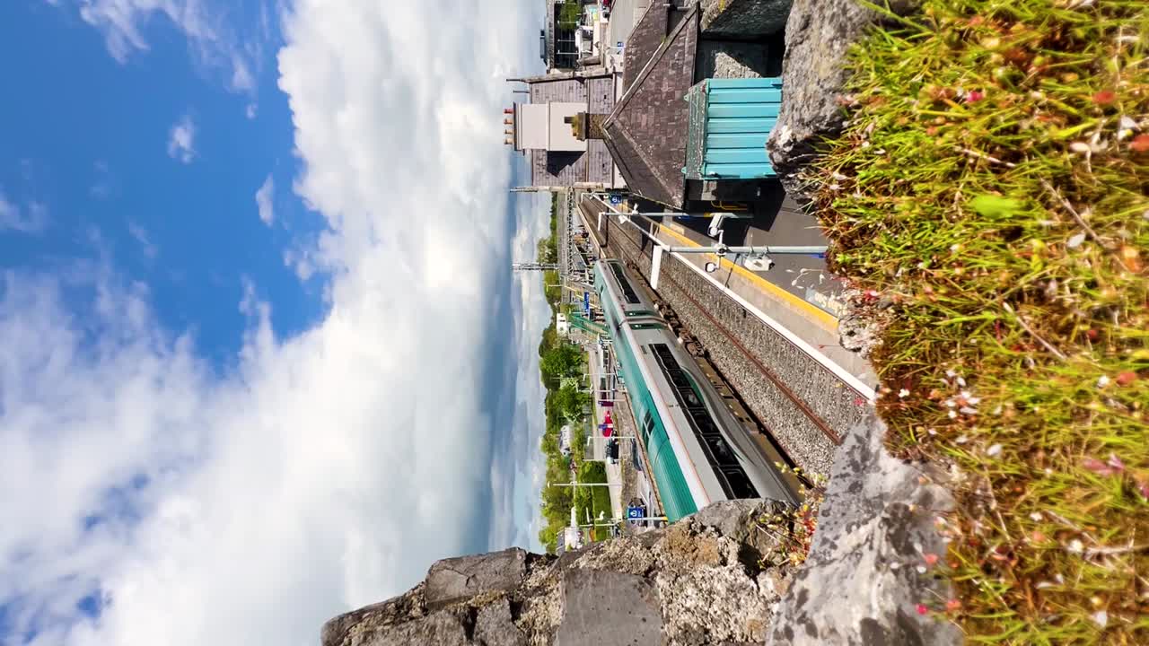 viaje en tren irlandés: llegada tranquila a la estación de tren de sallins en un hermoso día | vídeo vertical de desplazamiento urbano