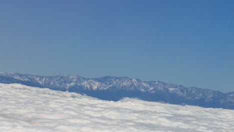 aerial view of snowy mountains above a sea of clouds