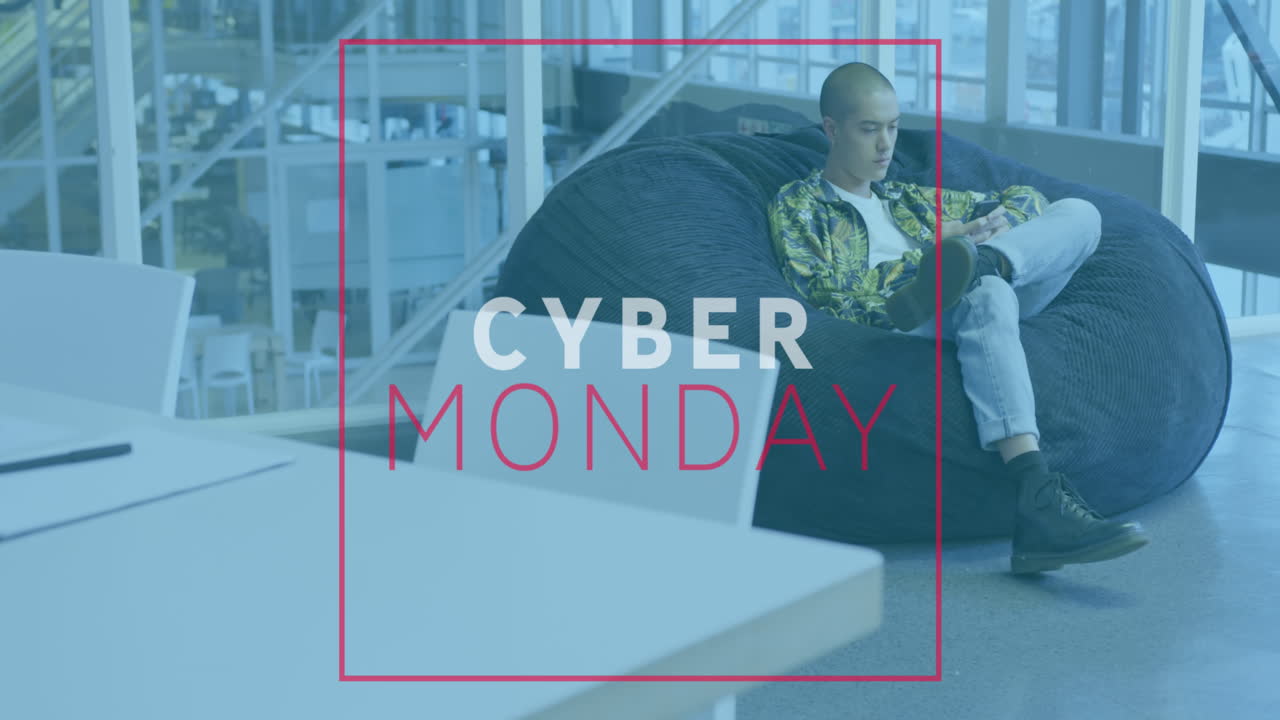 Animation of cyber monday text banner against biracial man using smartphone at office