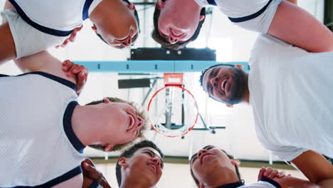 low angle view of male high school basketball players having team talk with coach