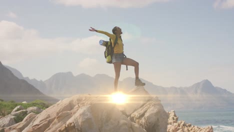 animation of light trails over african american woman with arms outstretched hiking