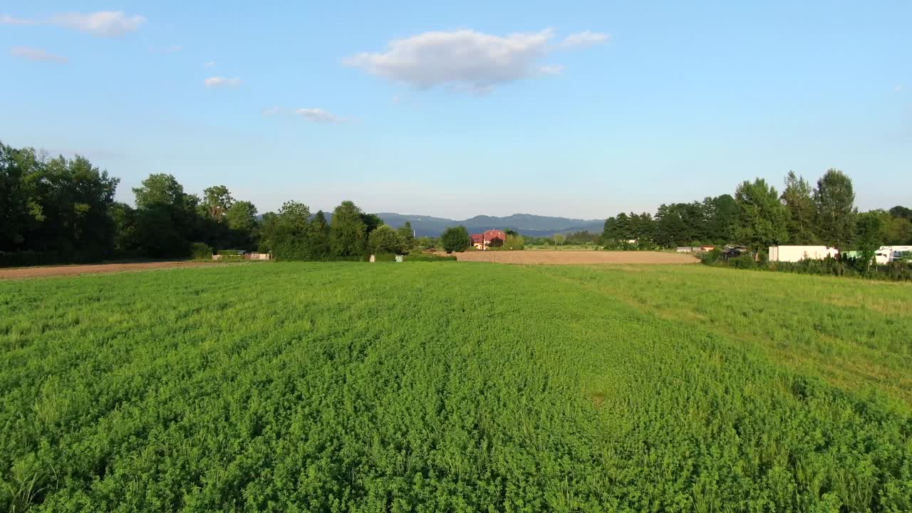 Campos verdes e currais em uma fazenda ao pôr do sol em Cerknica, Eslovênia. Fotografia aérea.
