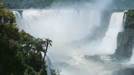 splashing water from aggressive streams from cliffs in iguacu falls, brazil, south america, misty rough crashing waterfalls in rough flowing river hidden in valley in nature filled green jungle