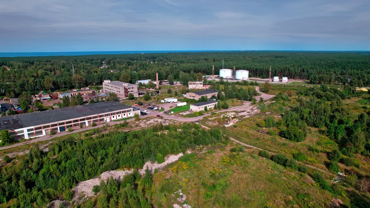 Aerial view of an abandoned industrial site in Latvia surrounded by forest