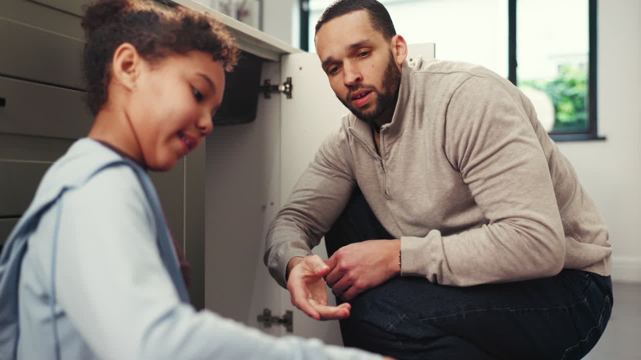 Father and Daughter Repairing Plumbing in Kitchen