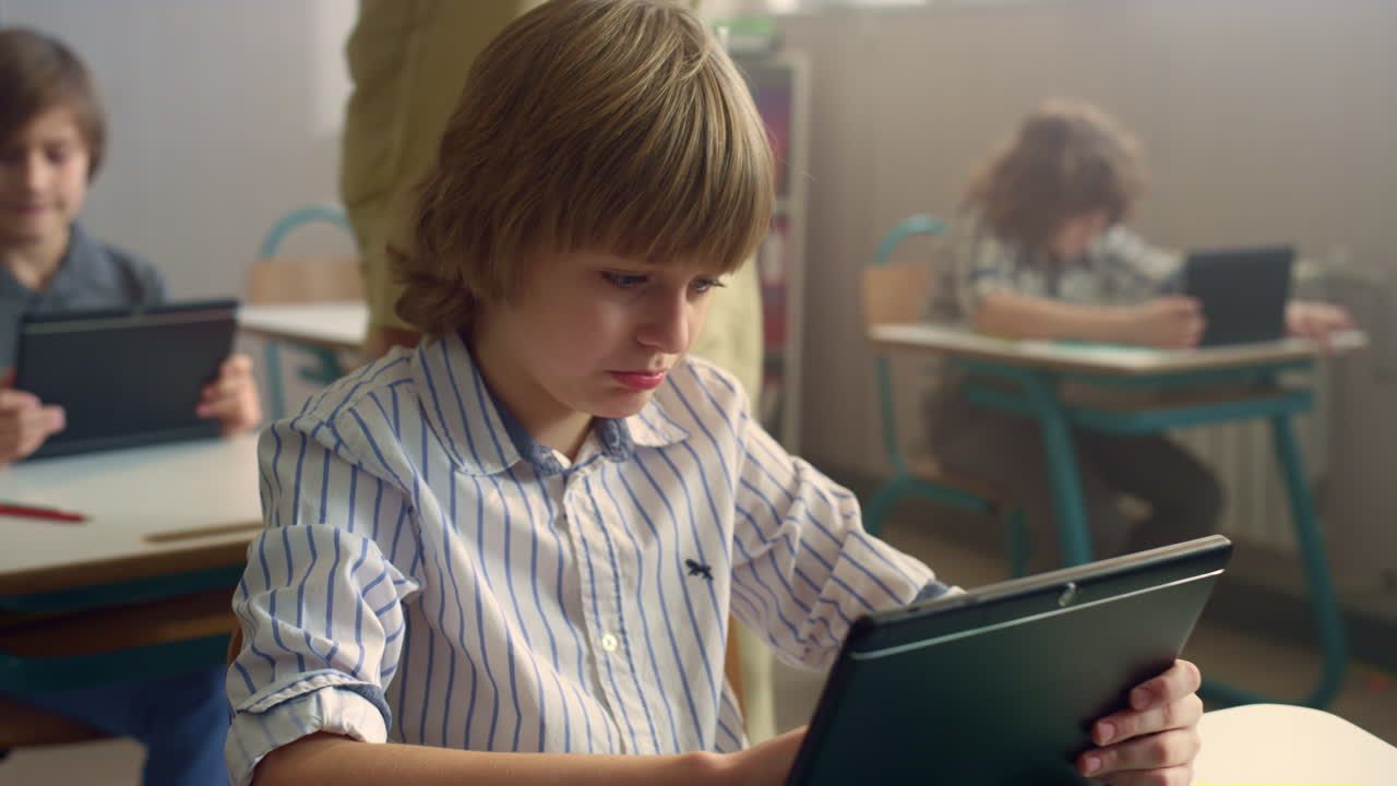 студент использует сенсорный планшет на цифровом планшете. мальчик просматривает интернет на планшете