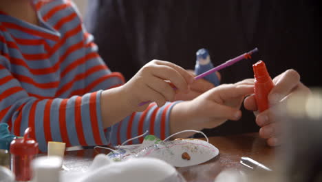 Primer-Plano-De-Padre-E-Hija-Pintando-Máscaras-En-Casa